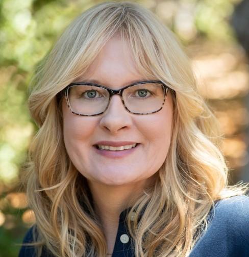 A woman with glasses smiling