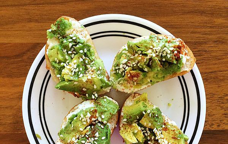 Four pieces of avocado toast on a plate