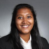 A woman in a suit smiling at the camera.