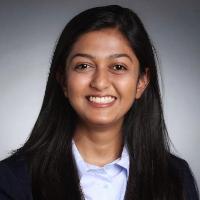 A professional woman smiling in a business suit.