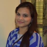 A person is smiling in a blue patterned outfit.