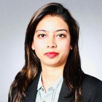 Business professional in a dark blazer and patterned blouse.