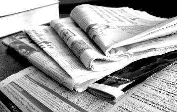 A stack of assorted newspapers.