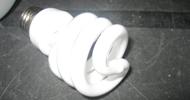 Compact fluorescent lightbulb on a dark surface.
