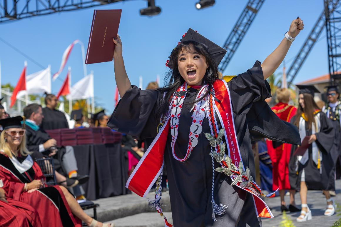 Student in cap and gown holding diploma